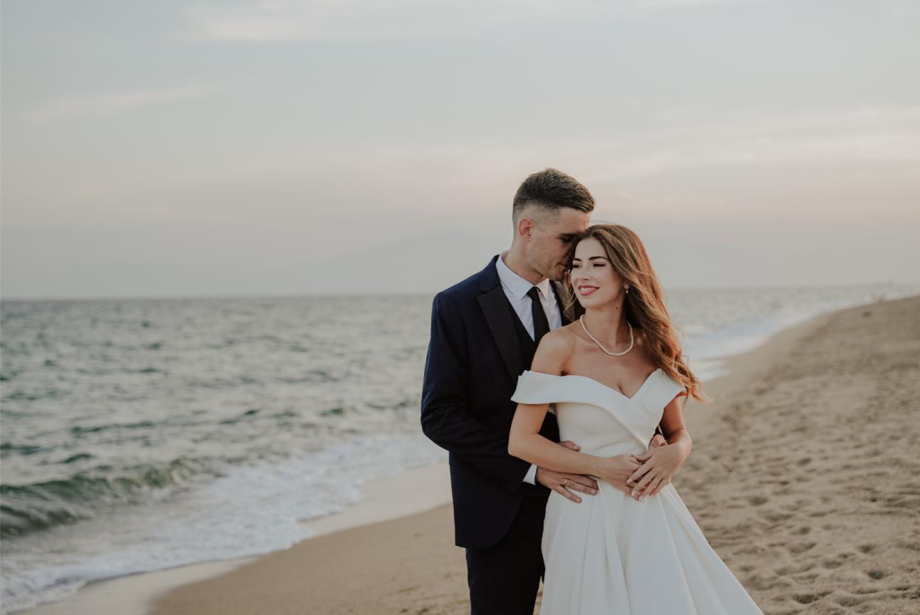 Newlyweds walking along the Aegean coast in Greece – timeless wedding photography style